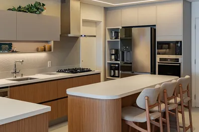 Cozinha moderna com ilha em madeira e bancada branca — reforma residencial