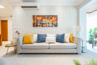 Sala de estar com sofá e quadro decorativo em apartamento reformado — Nord Engenharia Santos
