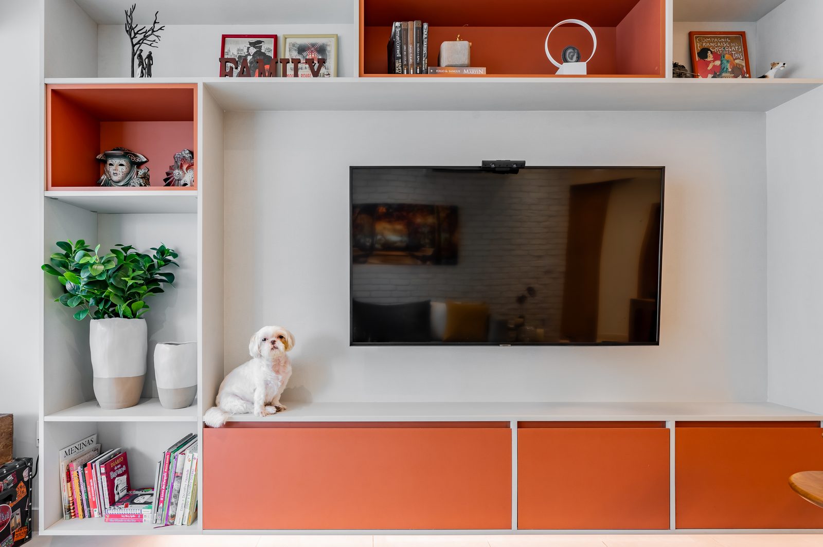 Estante de TV planejada com nichos coloridos em sala reformada — Santos SP