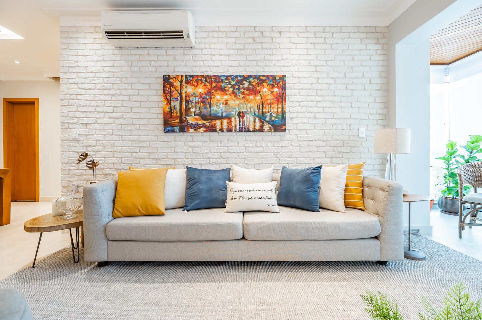 Sala de estar com sofá e quadro decorativo em apartamento reformado — Nord Engenharia Santos