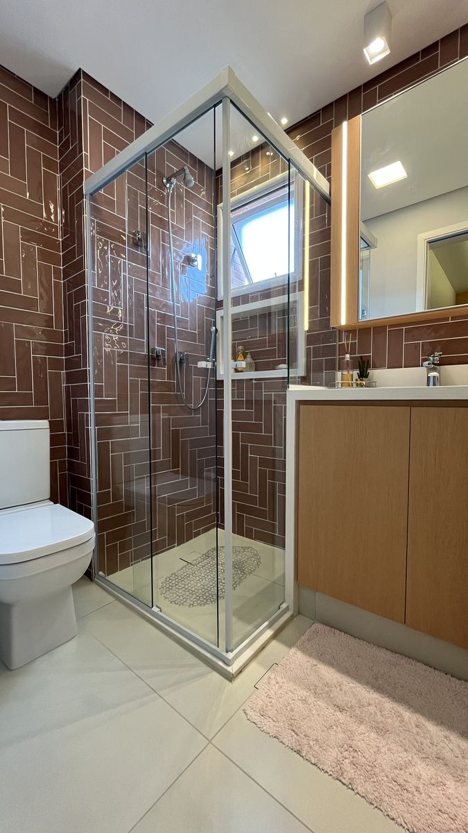 Banheiro com revestimento cerâmico terracota em paginação espinha de peixe — reforma residencial